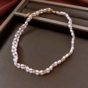 Détail du collier de perles plaqué or 18 carats sur fond de velours foncé