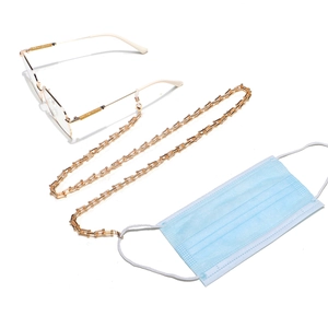 Golden chunky metal eyeglass and mask chain with U-shaped links on white background