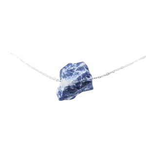 Irregular natural sodalite raw stone pendant necklace with silver chain on white background