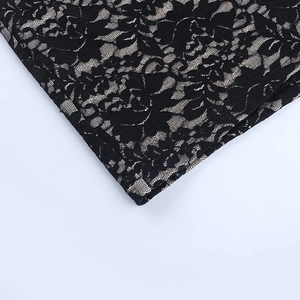 Détail de dentelle florale noire avec doublure chair sur une robe moulante sexy à col en V