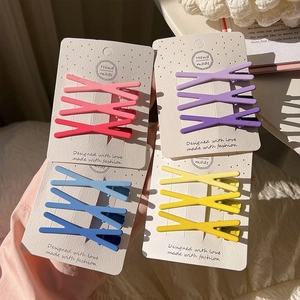Set of 12 colorful X-shaped hair clips in candy colors on display cards for girls