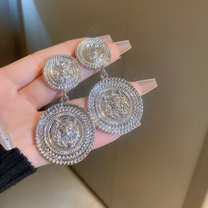 Close-up of vintage silver lion head geometric earrings with punk style details