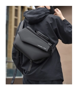 Detail of a black tactical chest bag with Fashion Bag lettering worn by a male model