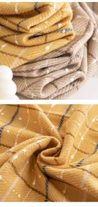 Macro shot of yellow and khaki plaid scarf showing soft herringbone weave and white speckles