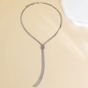 Detailansicht der silbernen Schlangenkette mit eleganten langen Fransen und Knotendesign