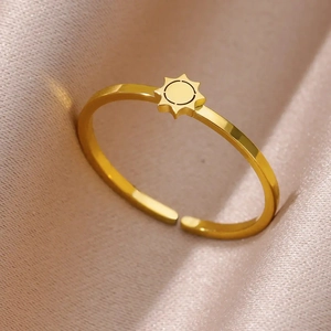 Macro shot of gold sunburst adjustable ring on elegant pleated champagne satin fabric