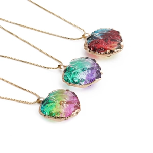Three gold box chain necklaces with colorful heart crystal pendants on white background