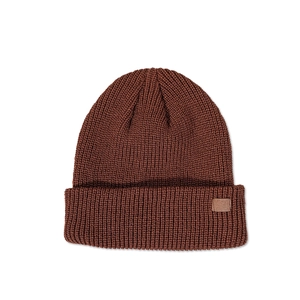 Detail of dark brown knit beanie showing thick texture and minimalist leather patch