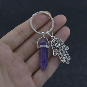 Close-up of Amethyst hexagonal pillar keychain with Hamsa Hand charm being held