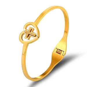 Polished gold stainless steel bangle with a heart-shaped cross charm design