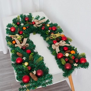 Christmas garland decoration with green pine needles, colorful balls, and linen bows