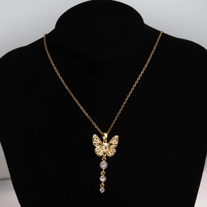 Vue détaillée du collier papillon doré avec pampilles en cristal sur buste en velours