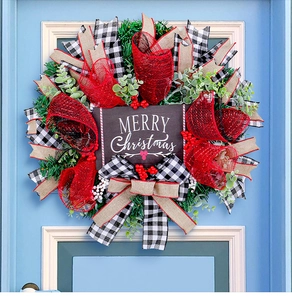 Detail of Christmas wreath with red mesh, plaid ribbons and Merry Christmas sign on blue door