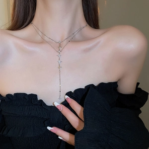Detail of double-layer stainless steel necklace with star pendants and tassel on model