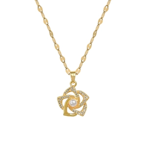 Gold rotating flower necklace with micro-pave crystals and white pearl center on white background