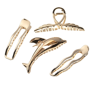 Set of four elegant golden metal hair claws in dolphin and geometric wing designs