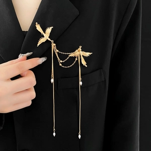 Detail of golden phoenix chain brooch with pearls on black blazer for women