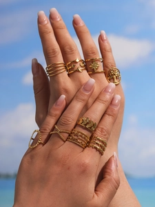 Close-up of 10 gold bohemian rings with star moon and tree of life motifs