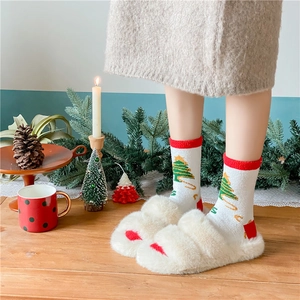 Close-up of thick Christmas socks with tree patterns and plush paw slippers in a cozy setting