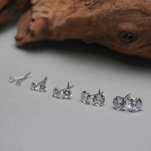 Détail montrant cinq tailles différentes de boucles d'oreilles clous en argent S925 et zircon