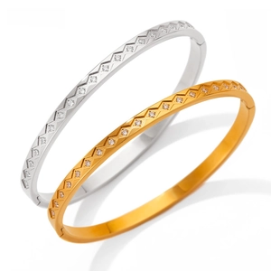 Close-up of gold and silver stainless steel bangles with sparkling zircon stone settings