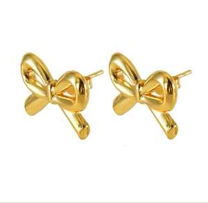 Detail of 18K gold-plated bow-knot stud earrings showing polished metallic texture