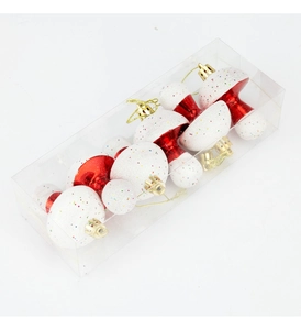 Glittery red mushroom Christmas ornaments set in a clear box with gold hanging cords