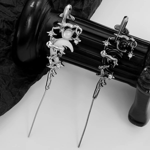 Gothic moon and star drop earrings with silver metal and black beads on dark background
