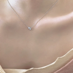 Close-up of 925 sterling silver necklace with three round zircon stones on collarbone