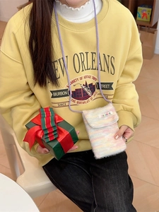 Rainbow plush knit crossbody phone pouch with a purple strap worn by a model