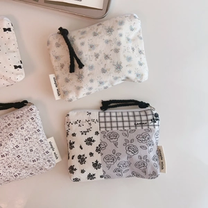Detail view of four floral cotton pouches with silver zippers and hand-woven pull cords