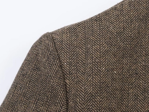Dettaglio macro del tessuto in misto lana spinato sulla spalla di un blazer