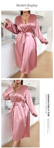 Detailed view of pink satin robe with long sleeves and adjustable waist tie in home setting