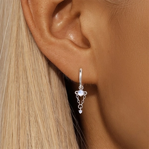 Close-up of S925 silver moonstone earring with chain tassel worn on a model ear