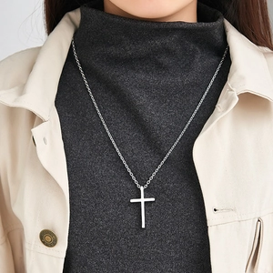 Men's titanium steel cross necklace with a silver finish worn over a sweater