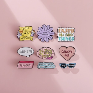 Lot de 9 pins en émail aux motifs de marguerites et slogans positifs sur fond rose pastel