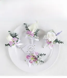 Detail of white and purple wedding boutonnieres with silk ribbons on a ceramic plate