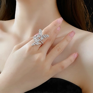 Detail of a hollow butterfly ring with sparkling zircons worn on a model's finger