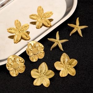 Golden stainless steel flower and starfish stud earring set on a metallic tray