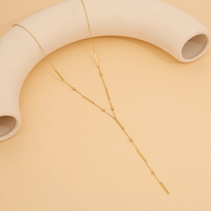 Detailed view of gold Y-shaped necklace with delicate beads and rectangular bars