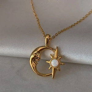Goldene Mond- und Sternhalskette mit Opal-Anhänger auf Seide und marmoriertem Hintergrund