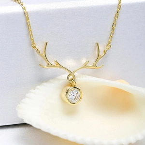 Close-up of golden reindeer antler necklace with a sparkling cubic zirconia stone