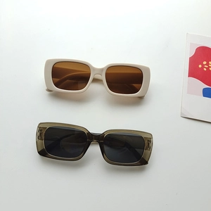 Detail view of two pairs of vintage rectangular acrylic sunglasses in cream and teal