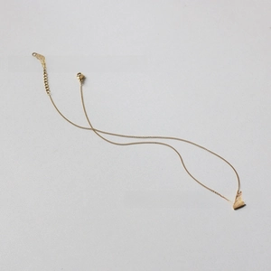 Macro detail of 18K gold plated square pendant on a minimalist vintage style chain