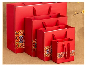 Detailed view of four red Chinese style gift bags with colorful ethnic patterns in various sizes