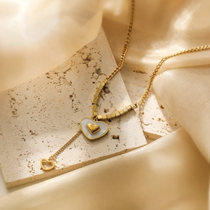 Gold plated heart pendant necklace featuring white shell inlay and unique block chain