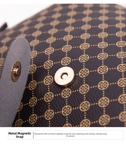 Macro view of gold magnetic clover clasp on dark brown printed leather shoulder bag