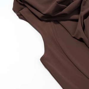 Détail de la couture de qualité et texture du tissu marron foncé sur la robe sans manches