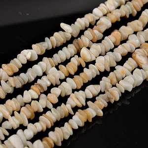 Macro shot of irregular natural shell stone beads in beige and white for DIY jewelry