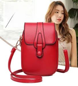 Detail of red pebbled leather phone crossbody bag with gold hardware and front flap